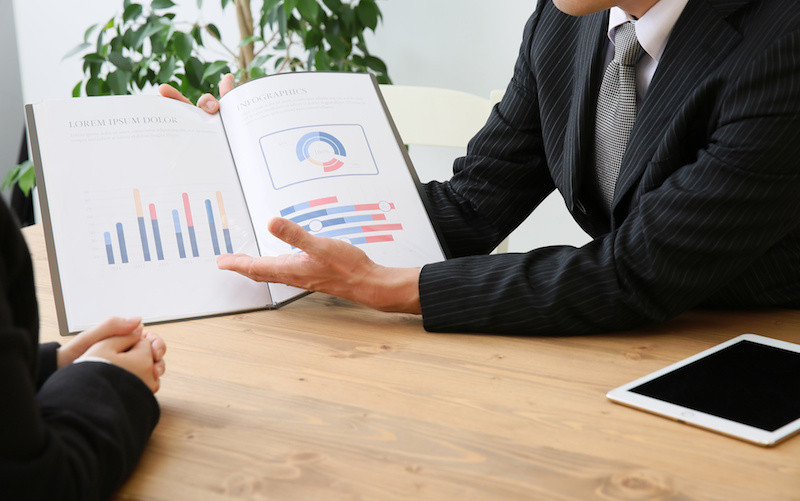 資料を持って説明をする男性